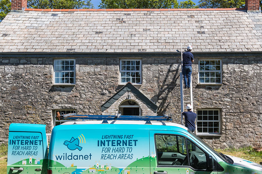 wildanet van pictured with workmen fitting broadband to cottage